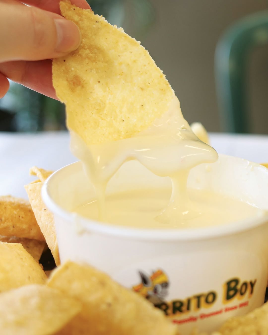 Burrito held up in front of Burrito Boy sign